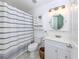 Well-lit bathroom with a striped shower curtain, vanity and round mirror, creating a serene and stylish space at 841 Waterside Dr # 202, Venice, FL 34285