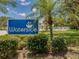 Waterside community sign surrounded by green shrubs and a palm tree against a bright blue sky at 841 Waterside Dr # 202, Venice, FL 34285