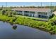 Exterior view of a multi-unit building, with lake views and lush greenery at 841 Waterside Dr # 202, Venice, FL 34285