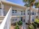 Condo featuring a private balcony with lush landscaping and access to outdoor amenities at 841 Waterside Dr # 202, Venice, FL 34285