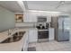 Kitchen features stainless steel appliances, quartz countertops and tile flooring at 841 Waterside Dr # 202, Venice, FL 34285