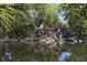 Beautiful waterfall cascading into a pond with lush greenery and a clear reflection of the sky at 841 Waterside Dr # 202, Venice, FL 34285