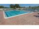 Spacious pool area with clear blue water, lined with lounge chairs, perfect for relaxation and recreation at 841 Waterside Dr # 202, Venice, FL 34285