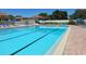 A well maintained outdoor swimming pool with clear blue water, surrounded by chairs and umbrellas at 841 Waterside Dr # 202, Venice, FL 34285