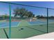 Community tennis court with vibrant colors, surrounded by fencing, and ready for a match at 841 Waterside Dr # 202, Venice, FL 34285