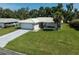 Charming single-story home with a well-manicured lawn, an attached garage, and a light-colored tiled roof at 903 E Shannon Ct, Venice, FL 34293