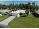 Beautiful single-story home featuring a light-colored tiled roof, lush green lawn, and an attached two-car garage at 903 E Shannon Ct, Venice, FL 34293