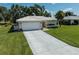 Well-maintained single-story home featuring a two car garage, light-colored stucco, and manicured lawn and landscaping at 903 E Shannon Ct, Venice, FL 34293