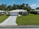 Well-maintained single-story home featuring a two car garage, light-colored stucco, and manicured lawn and landscaping at 903 E Shannon Ct, Venice, FL 34293