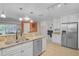 Open kitchen with granite countertops, stainless steel appliances, and access to a bright dining area at 903 E Shannon Ct, Venice, FL 34293