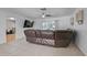 Bright living room featuring a large brown leather couch and tile flooring at 903 E Shannon Ct, Venice, FL 34293
