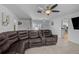 Bright living room featuring a large brown leather couch with tile flooring at 903 E Shannon Ct, Venice, FL 34293