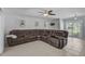 Bright living room featuring a large brown leather couch with cup holders and tile flooring at 903 E Shannon Ct, Venice, FL 34293