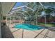 Screen enclosed in-ground pool with brick paver patio and screened enclosure, and view of the backyard at 903 E Shannon Ct, Venice, FL 34293