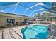 Screen enclosed in-ground pool with brick paver patio and view of the covered outdoor patio with seating area at 903 E Shannon Ct, Venice, FL 34293