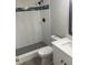 Renovated bathroom with textured tile shower, rain shower head, and hexagonal tile in shower floor at 9110 Lunar Ln, Port Richey, FL 34668
