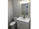 Bathroom featuring vanity with quartz countertop, white cabinets, brushed nickel faucet and hardware, and standard toilet at 9110 Lunar Ln, Port Richey, FL 34668