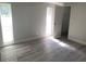 Clean and spacious bedroom with two windows providing natural light and gray wood look flooring at 9110 Lunar Ln, Port Richey, FL 34668