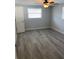 Cozy bedroom with neutral paint, modern ceiling fan and light, and wood-look gray flooring at 9110 Lunar Ln, Port Richey, FL 34668