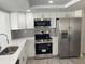 Beautiful kitchen featuring stainless steel appliances, white cabinets, quartz countertops, and gray backsplash at 9110 Lunar Ln, Port Richey, FL 34668