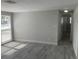 Bright living room with updated gray floors and neutral walls; hallway view at 9110 Lunar Ln, Port Richey, FL 34668