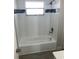 Clean bathroom shower with decorative gray tile accents, white tile, and brushed chrome shower head and hardware at 9110 Lunar Ln, Port Richey, FL 34668