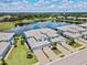 Aerial view of the townhome showcasing the community, lake, landscaping, and paver driveway at 935 Tidewater Shores # 721, Bradenton, FL 34208