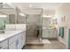 Bright bathroom featuring dual sinks, a large mirror, and a glass enclosed walk-in shower at 935 Tidewater Shores # 721, Bradenton, FL 34208