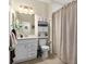 Cozy bathroom with a neutral shower curtain, white vanity, and convenient storage shelves at 935 Tidewater Shores # 721, Bradenton, FL 34208
