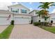 Exterior view of the townhome with a gray exterior, attached garage, and well-manicured lawn at 935 Tidewater Shores # 721, Bradenton, FL 34208