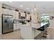 Modern kitchen with stainless steel appliances, an island with seating, and sleek white cabinets at 935 Tidewater Shores # 721, Bradenton, FL 34208