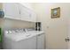 Efficient laundry room with a washer, dryer, and storage cabinets for convenience at 935 Tidewater Shores # 721, Bradenton, FL 34208