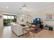 Living room features comfortable seating, tile flooring, and a stylish decor with access to the lanai at 935 Tidewater Shores # 721, Bradenton, FL 34208