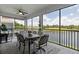 Screened lanai featuring a ceiling fan, outdoor dining set, and lovely views of the water at 935 Tidewater Shores # 721, Bradenton, FL 34208