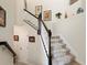 Interior staircase with carpet runner and dark wood railings contrasted by light walls and decor at 935 Tidewater Shores # 721, Bradenton, FL 34208