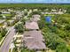 Aerial view of homes, streets, and green landscape with a lake, fountain, and trees at 9361 Carnaby Dr, Venice, FL 34293