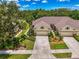 Aerial view of homes with well-maintained lawns, driveways, and mature trees at 9361 Carnaby Dr, Venice, FL 34293