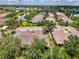 A detailed aerial view of the property showcases the home’s setting among lush trees and manicured landscaping at 9361 Carnaby Dr, Venice, FL 34293