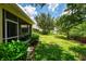 Expansive backyard featuring lush greenery, a pond view, and a glimpse of the screened-in lanai at 9361 Carnaby Dr, Venice, FL 34293