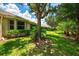 Backyard featuring lush greenery, mature trees, well-kept lawn, and privacy hedges along the border at 9361 Carnaby Dr, Venice, FL 34293