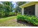 Backyard featuring well-maintained lawn, lush landscaping, and an enclosed patio area at 9361 Carnaby Dr, Venice, FL 34293