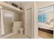 Bright bathroom with a glass door shower and view into the main bedroom at 9361 Carnaby Dr, Venice, FL 34293