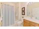 Clean bathroom featuring a shower with bathtub, neutral tile, vanity, and fresh decor at 9361 Carnaby Dr, Venice, FL 34293