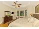 Comfortable bedroom featuring a ceiling fan, bay window, and dark wood furniture at 9361 Carnaby Dr, Venice, FL 34293