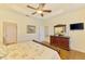 This bedroom features wood floors, a ceiling fan, and a flat screen TV on the wall at 9361 Carnaby Dr, Venice, FL 34293