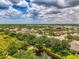 A tranquil neighborhood view showcasing manicured lawns, mature trees, and picturesque ponds in a sunny setting at 9361 Carnaby Dr, Venice, FL 34293