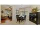 Elegant dining room features a large window, a stylish chandelier, and a view of the living room at 9361 Carnaby Dr, Venice, FL 34293