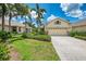 Charming home featuring a well-manicured lawn, lush landscaping, and a two-car garage at 9361 Carnaby Dr, Venice, FL 34293