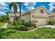 Charming home featuring a well-manicured lawn, lush landscaping, and a two-car garage at 9361 Carnaby Dr, Venice, FL 34293