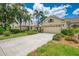 Charming home featuring a well-manicured lawn, lush landscaping, and a two-car garage at 9361 Carnaby Dr, Venice, FL 34293